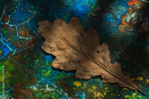 Fluid art - autumn oak leaf. Abstraction on a dark background