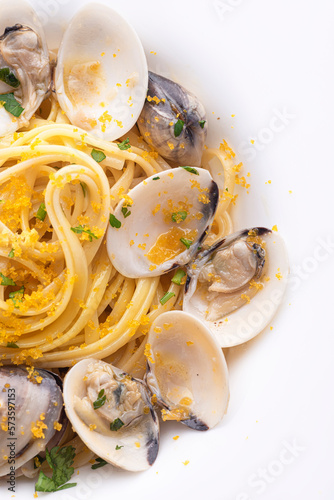 Spaghetti pasta with clams (vongole) and  bottarga (dried tuna or mullet caviar, roy).  Classic  summer seafood dish of the Sardinia, Sicily islands and Napoli. Italian healthy cuisine, close up