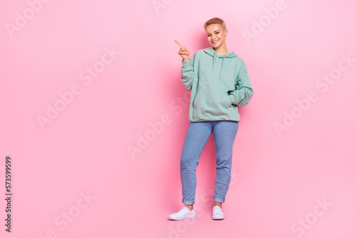 Full length photo of adorable pretty lady arm presenting empty space opening new shop stylish clothes isolated on pink color background