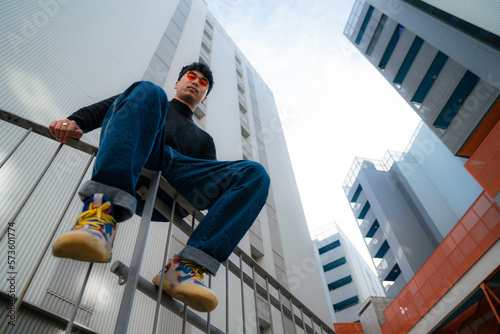young asian man wearing cool red glasses on modern building background urban lifestyle black t-shirt