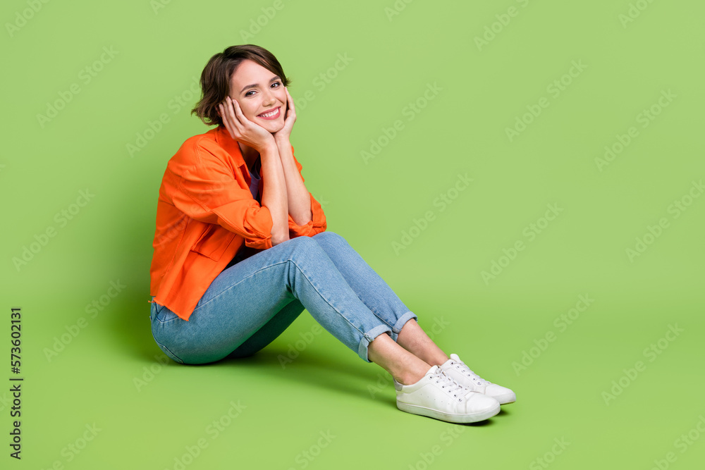 Full length photo of dreamy sweet woman wear denim jacket hands arms cheeks cheekbones empty space isolated green color background Full length photo of dreamy sweet woman wear denim jacket hands arms cheeks cheekbones empty space isolated green color background