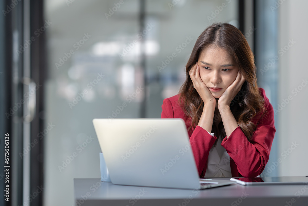 Asian businesswoman sitting in office stressed and fatigued from overwork on financial matters on office desk. Asian businesswoman sitting in office stressed and fatigued from overwork on financial matters on office desk.