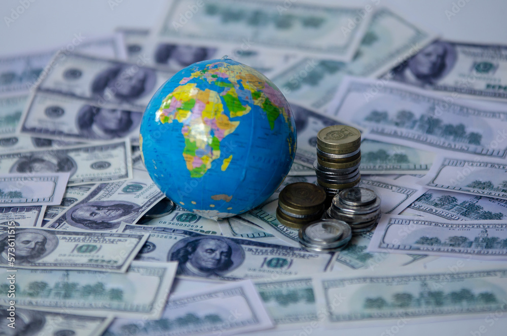globe on dollar banknote and coins, saving and managing money, transport, transportation insurance business technology, economic crisis risk and problem concept. selective focus globe on dollar banknote and coins, saving and managing money, transport, transportation insurance business technology, economic crisis risk and problem concept. selective focus