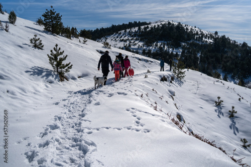 Family with four children and dog on a walk outdoors in winter nature