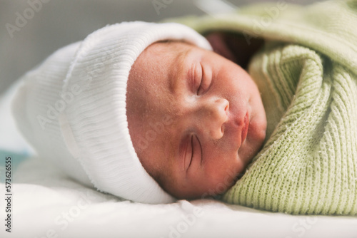 Foto Newborn baby sleeping in crib. Babyhood concept.