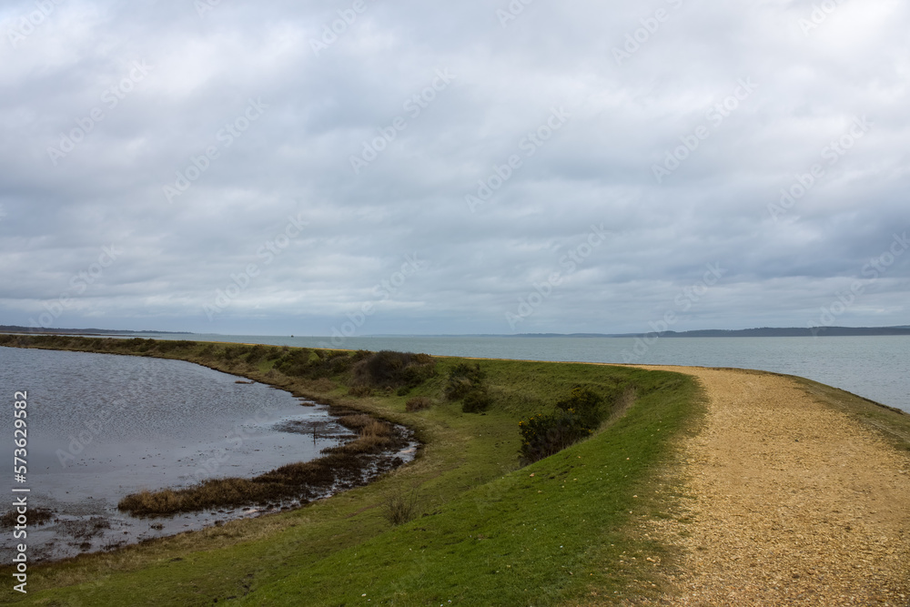 Footpath along The Solent Way trail at Lymington Hampshire England on a winter day with cloudy sky background Footpath along The Solent Way trail at Lymington Hampshire England on a winter day with cloudy sky background