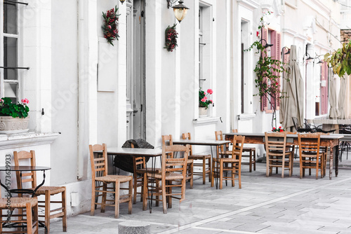 Beautiful bright summer cafe with wooden chairs on the street of Cyprus. Selective focus