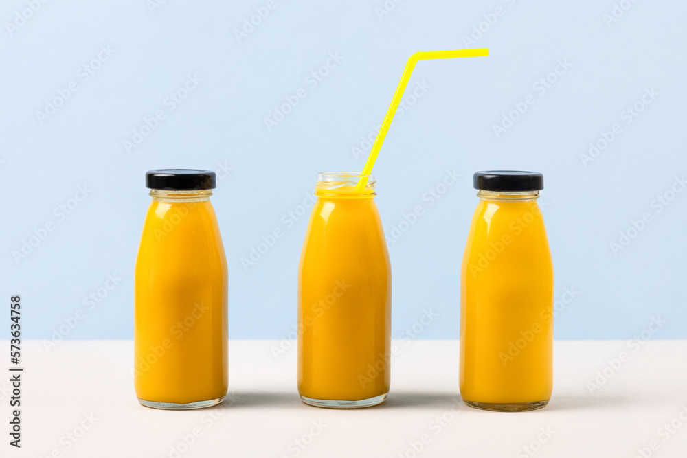 Three pineapple smoothies for healthy eating in glass bottles with a straw. Healthy, detox and dietary nutrition concept. Three pineapple smoothies for healthy eating in glass bottles with a straw. Healthy, detox and dietary nutrition concept.