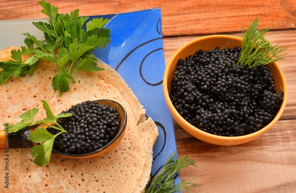 Pancakes with black caviar, cooked for Maslenitsa. Maslenitsa is an East Slavic traditional holiday celebrated during the week before Lent. Pancakes with black caviar, cooked for Maslenitsa. Maslenitsa is an East Slavic traditional holiday celebrated during the week before Lent.