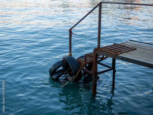 Old pier. Place of entry into the water. Tires on the pier.