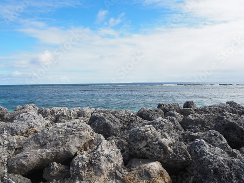 stone wall at beach in the Caribbean - blue ocean water in the evening photo