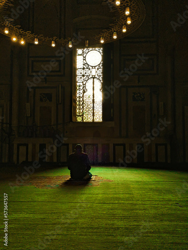 a person praying luminated by the window  photo