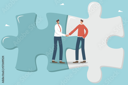 Collaboration, cooperation or partnership and agreement to help business success, business merger or acquisition, end of negotiations, success, businessmen complete a deal and shake hands in a puzzle.