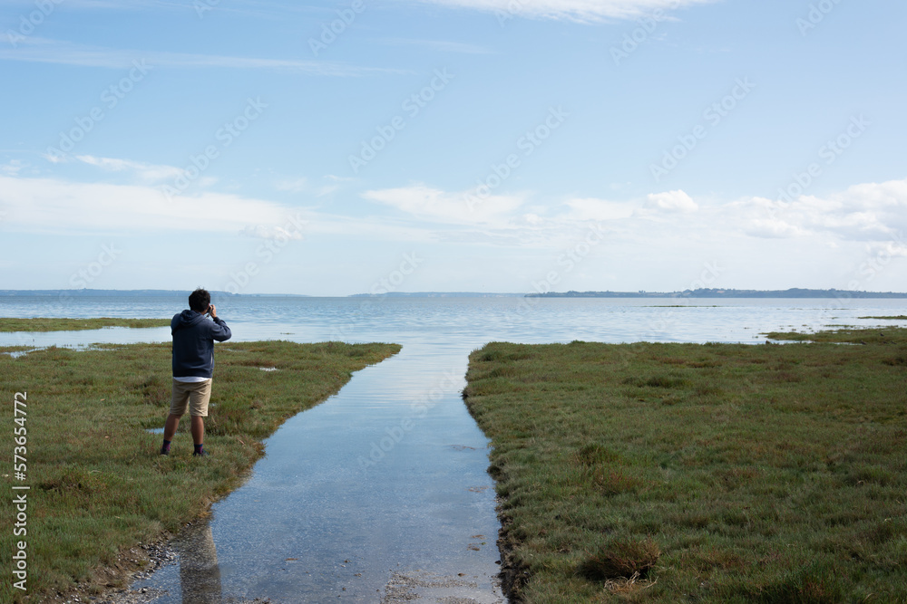 Hombre fotografiando el paisaje en la playa .
