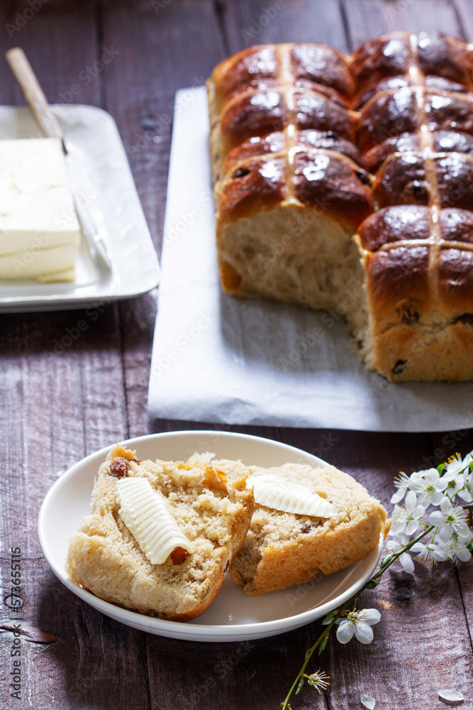 Cross buns served with butter, honey and tea. Easter breakfast.