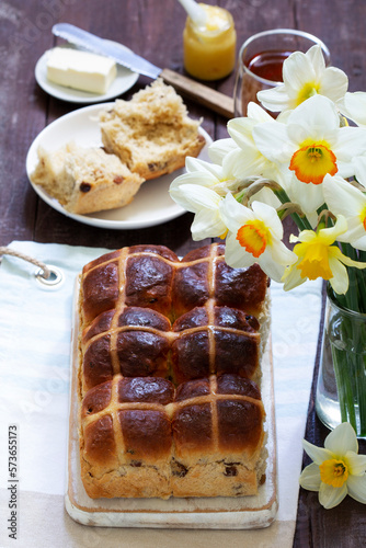 Cross buns served with butter, honey and tea. Easter breakfast.
