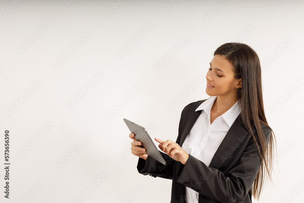 Portrait of successful business woman with tablet in her hands, dressed in white shirt and black jacket on isolated white background. Studio shot of attractive brunette girl Portrait of successful business woman with tablet in her hands, dressed in white shirt and black jacket on isolated white background. Studio shot of attractive brunette girl
