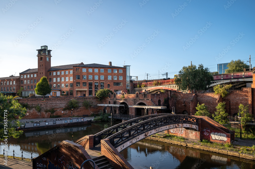 Narrowboat moored on Bridgewater Canal in Deansgate against a blue skyline from Castle field Basin, Manchester, north-west England