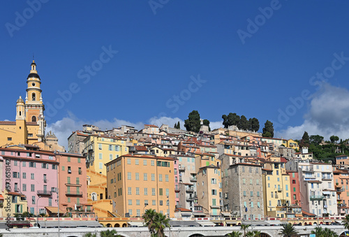 Church tower and colorful old buildings in Menton France summer season