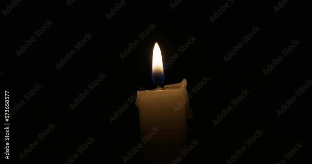 The candle burns with a soft yellow flame. Isolated candle burning The candle burns with a soft yellow flame. Isolated candle burning