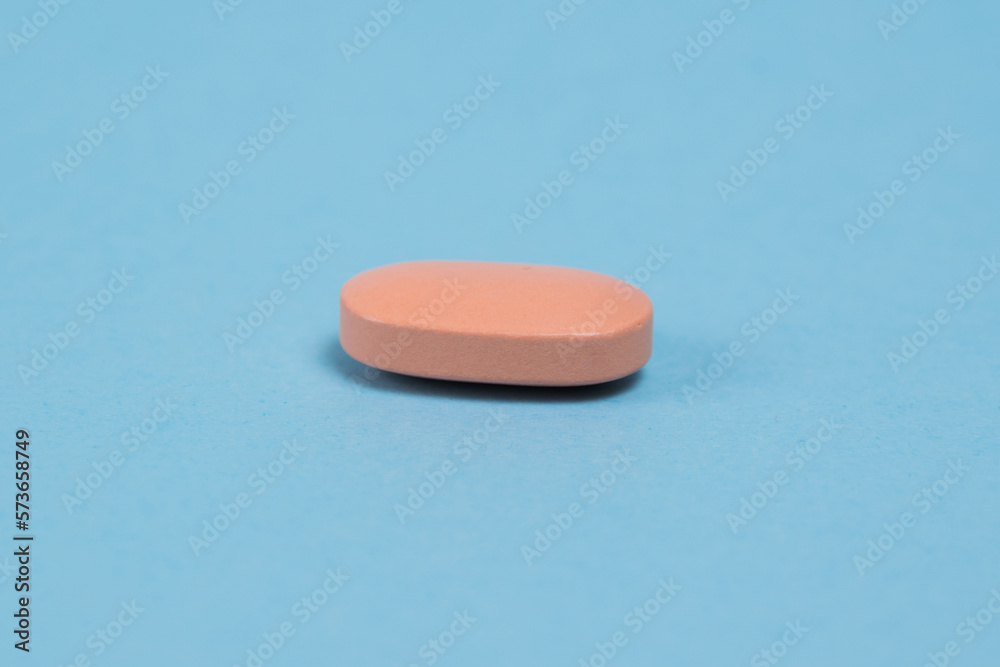 Pink pill macro on blue paper background with copy space Pink pill macro on blue paper background with copy space