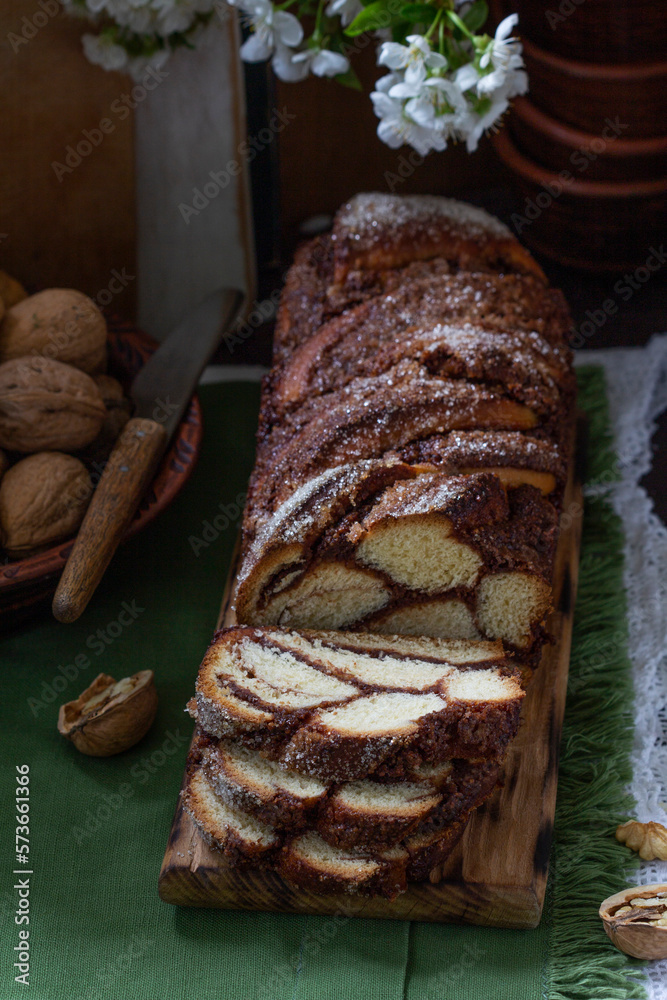 Traditional Easter bread with chocolate and nut filling on a wooden background.