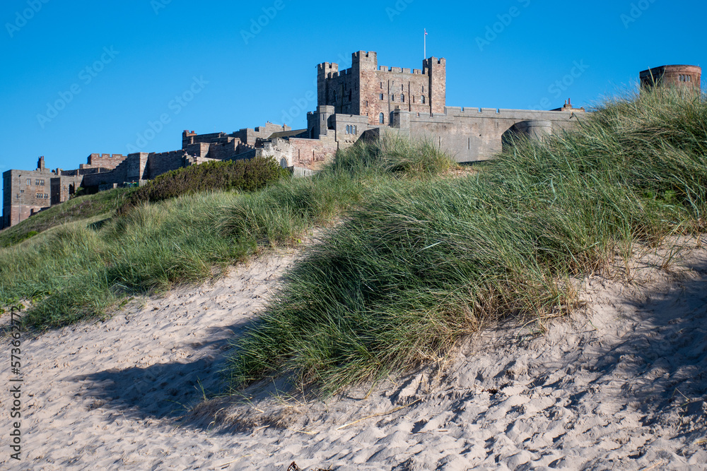 Bamburgh Castle across the sand dunes. Summer 2022 in Northumberland, UK