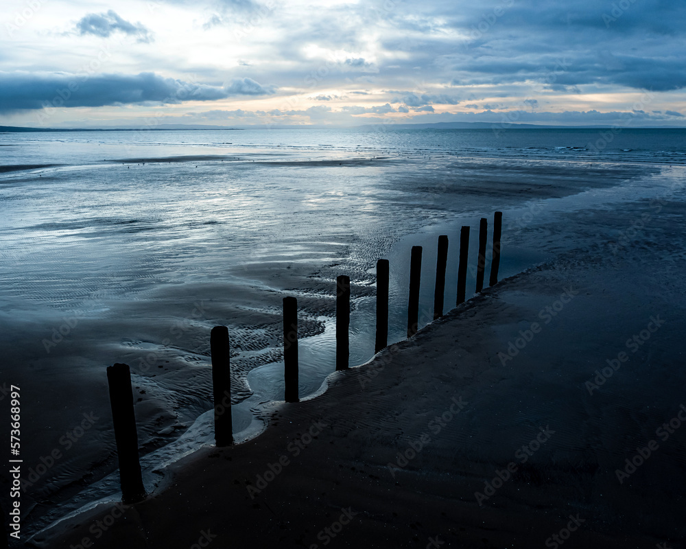 Obraz premium A line of groynes, Stevenston Beach, Saltcoats, North Ayrshire, Scotland, UK Blue