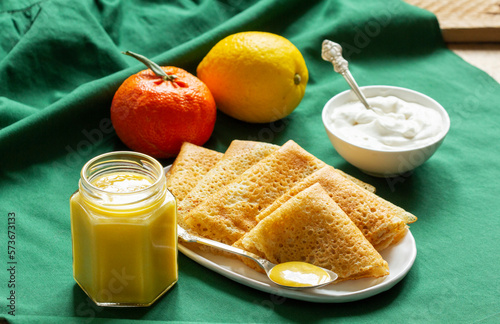 Obraz na płótnie Pancakes served with fruit curd and sour cream, a traditional meal for Maslenitsa and Carnival. w salonie