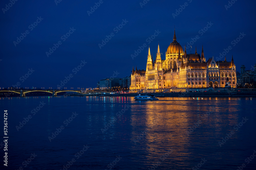 Illuminated Hungarian Parliament building and Margit Hid, Margaret Bridge night-time view with reflection in Danube river, Budapest, Hungary.