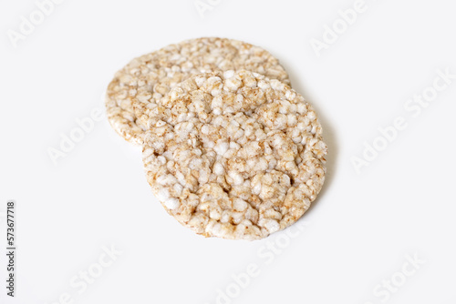 Two round rice cakes lying on top of each other on a white isolated background. Crispy rice diet product for a healthy lifestyle. Top view of rice cakes on a white background