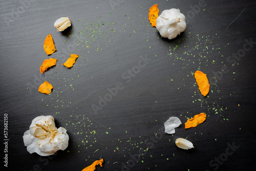 Healthy sweet potato chips with garlic on dark wood background