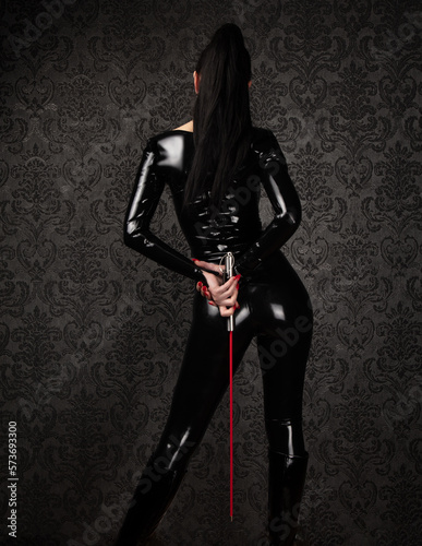 Sexy Dominant Woman in Latex Catsuit with Whip