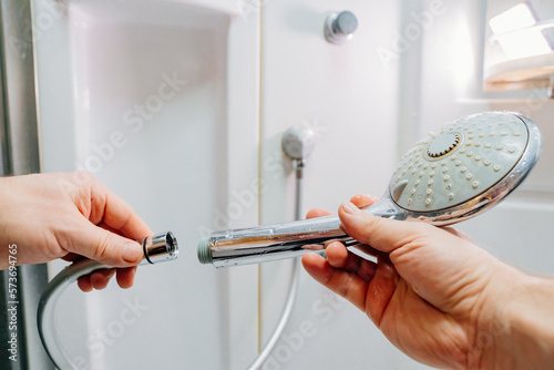 Bild auf Leinwand men's hands screw the shower head onto a new hose.