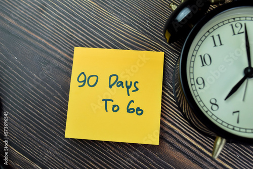 Concept of 90 Days To Go write on sticky notes isolated on Wooden Table.