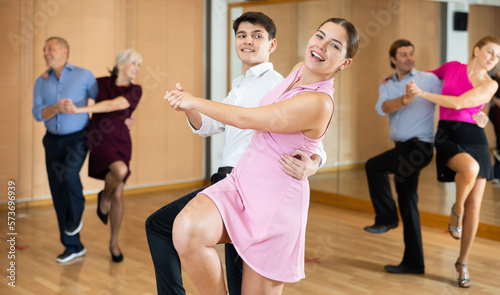 Young happy couple performing a paired dance in ballroom