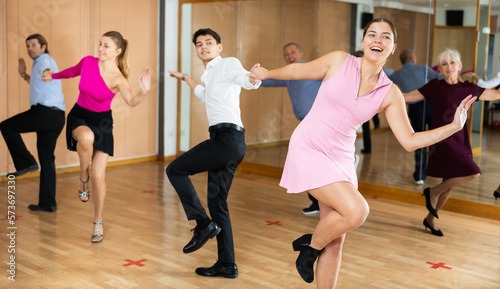 Active young pair practicing Latino dance in training hall during dancing-classes. Pairs training ballroom dance