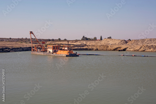A floating dredger extracts sand