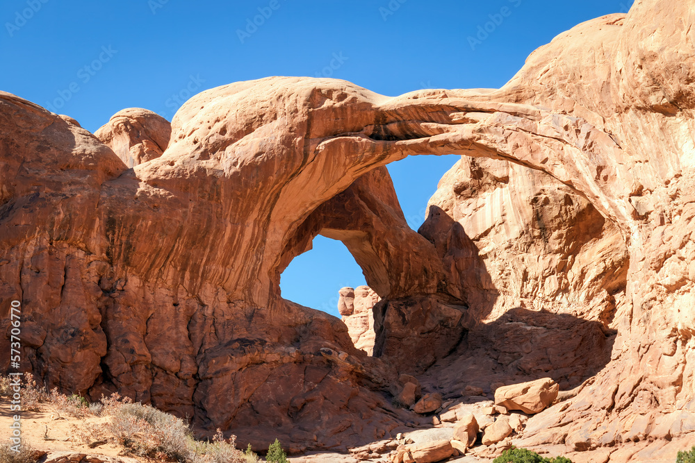 Three red rock arch formation in the desert of Arches National Park Utah with a clear blue sky.