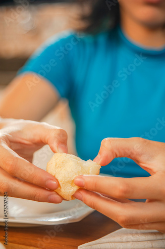 Young womans hand opening a cheese bread.