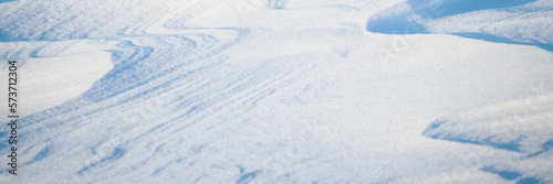 Snow texture. Wind sculpted patterns on snow surface. Wind in the tundra and in the mountains on the surface of the snow sculpts patterns and ridges. Arctic, Polar region. Winter panoramic background.