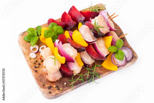 Uncooked meat skewer.Skewers with pieces of raw meat.Chicken Skewers breast fillet meat.Raw chicken meat skewers with vegetables,plums,yellow pepper,onions,with spices,herbs white background.Top view. photo