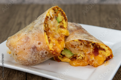 Overhead view of chorizo breakfast burrito with eggs, salsa, and cheese all wrapped in a grilled flour tortilla to eat