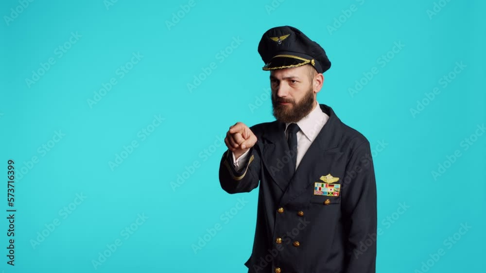 Plane captain in aviation uniform pointing at camera and choosing, saying i want you for commercial flights aircrew. Young male pilot flying airplane and acting confident, feeling successful. Plane captain in aviation uniform pointing at camera and choosing, saying i want you for commercial flights aircrew. Young male pilot flying airplane and acting confident, feeling successful.