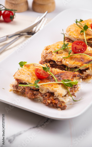 Schilderij op canvas Sliced lasagna on a white platter