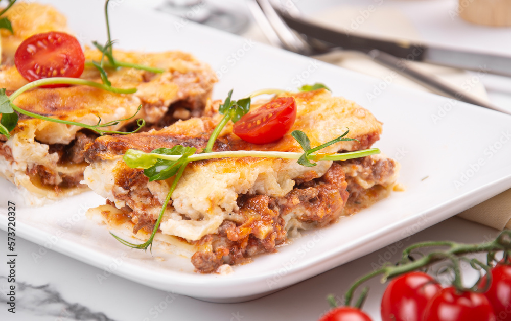 Lasagna cut into portions served on a white dish Lasagna cut into portions served on a white dish