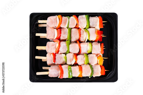 Skewers with pieces of raw meat, red, yellow and green pepper, on white background.Uncooked mixed meat skewer with peppers.Top view.Close-up.