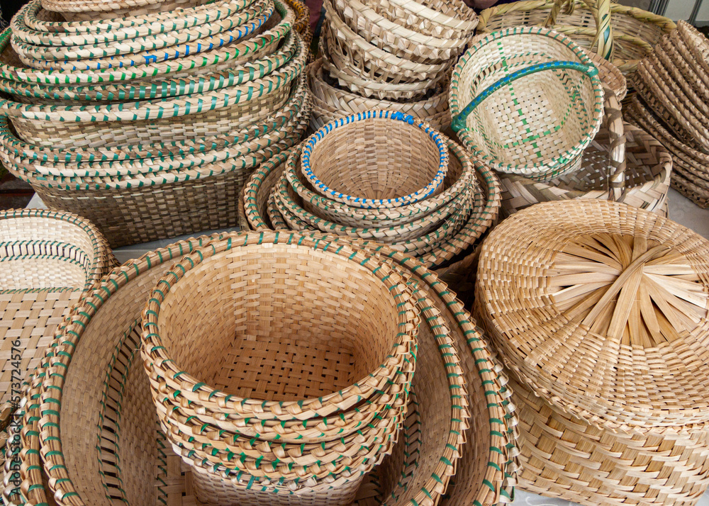 A pile of handmade traditional woven baskets made from straw, natural fiber, for sale at the outdoor market in Cuenca, Ecuador