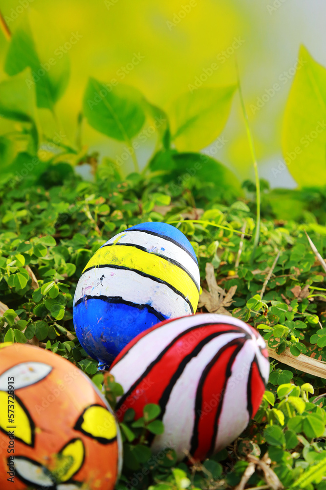 Painted Easter eggs in the grass with a blurred green background
