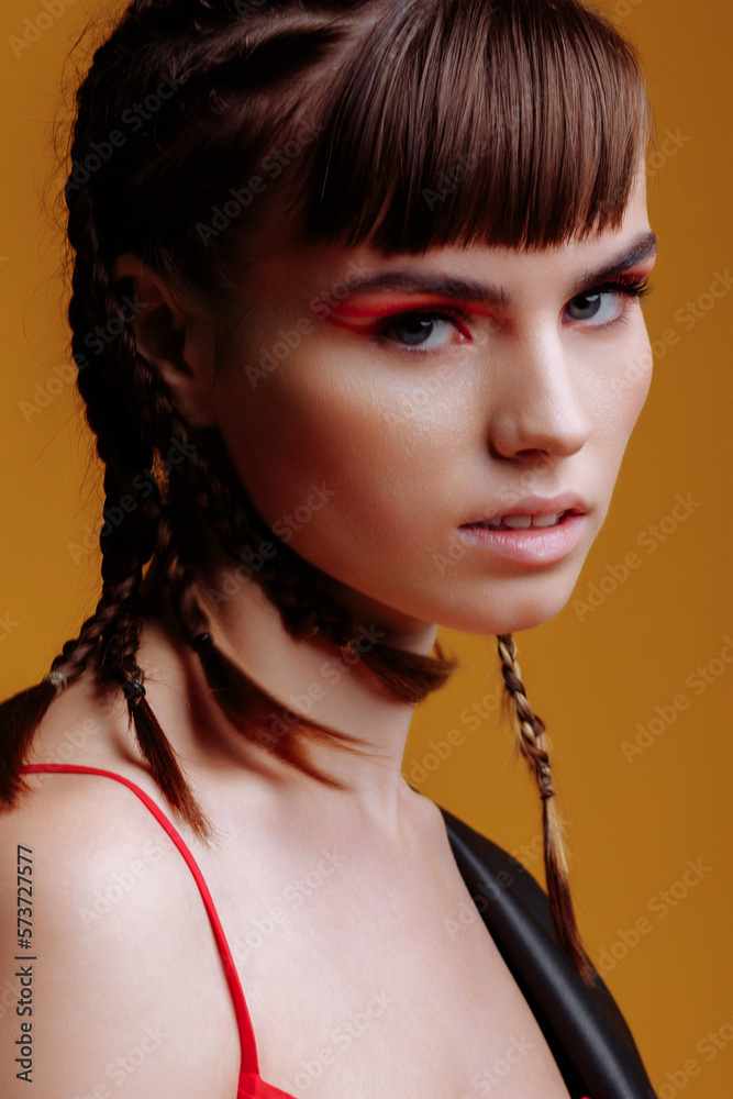 Portrait of a beautiful female model in a red dress, black leather